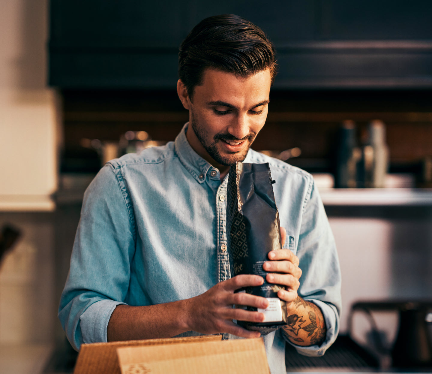 Man opening and smelling a fresh bag of Peet's Coffee